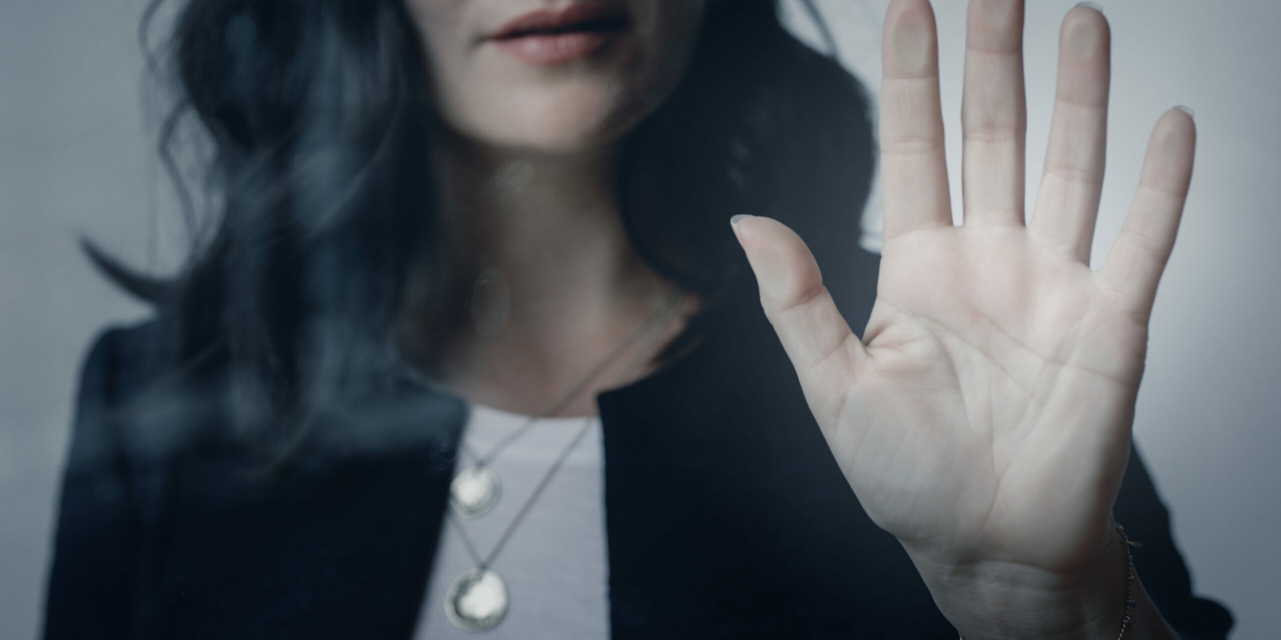 Harcèlement Moral Image d'une femme tendant la main avec un geste de stop, symbolisant la lutte contre le harcèlement moral - Axia Consultants